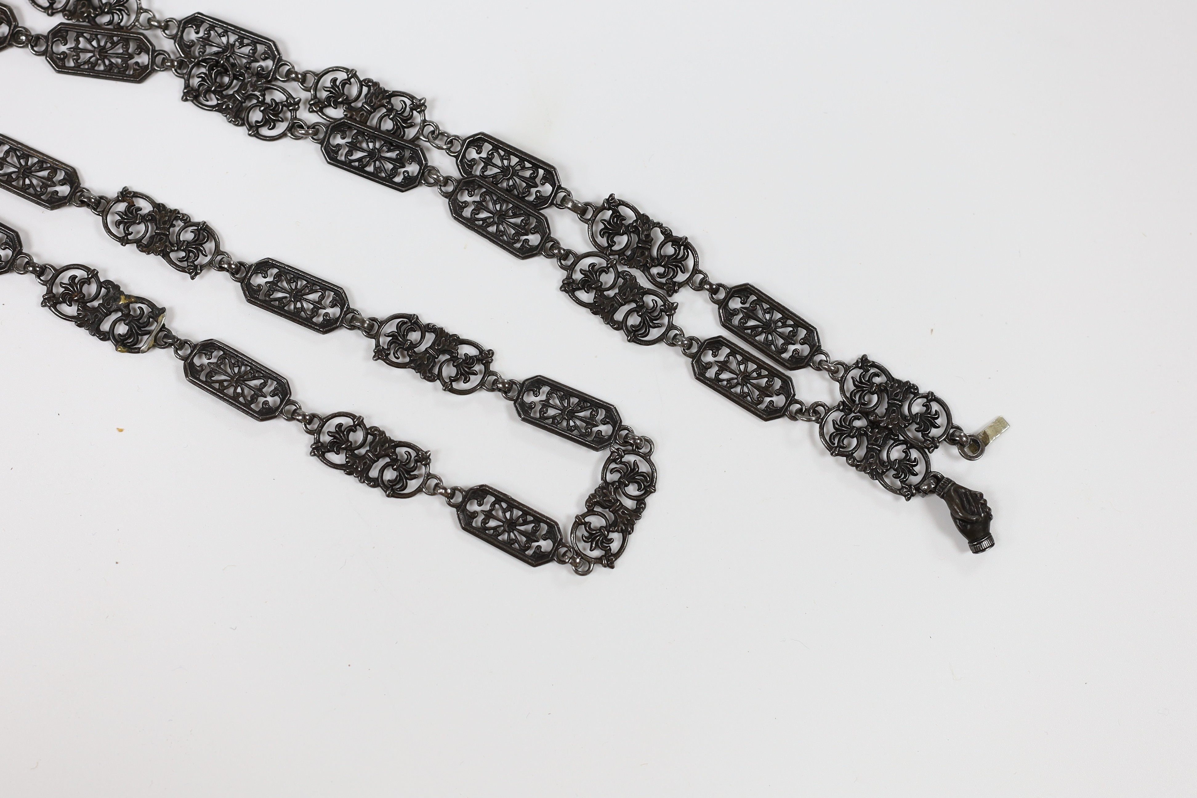 A 19th century Berlin iron work long necklace, with pierced octagonal and scrolling links, the clasp modelled as clasped hands, 114cm, (two small repairs to one link).